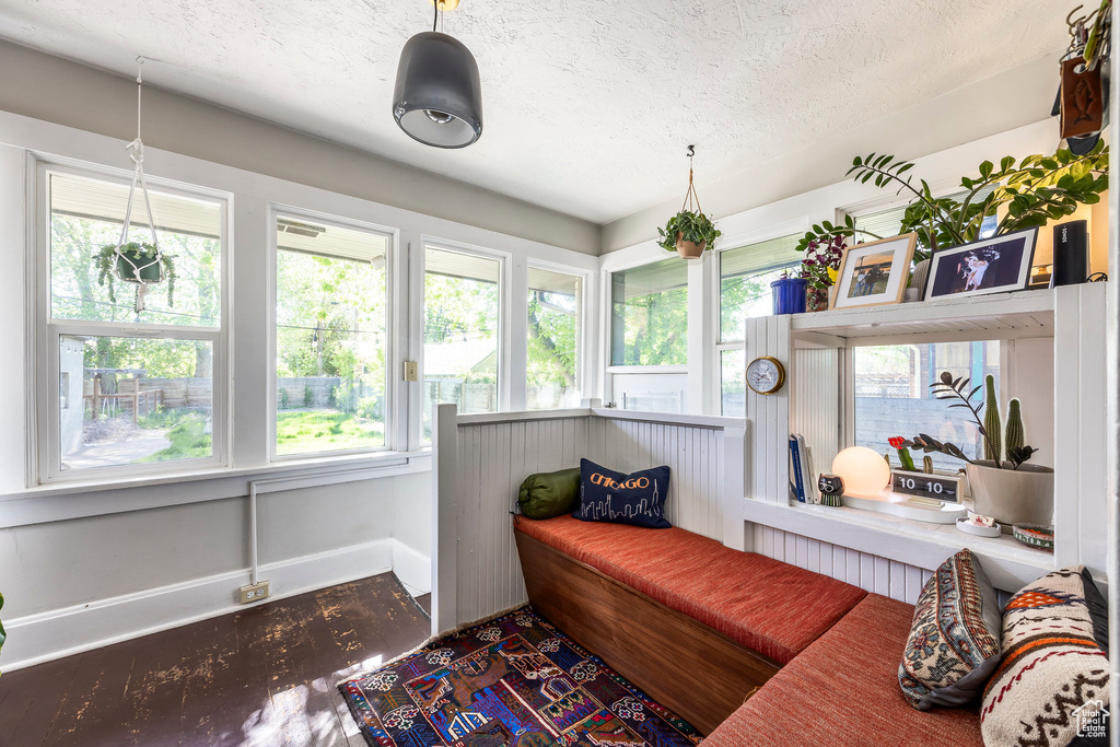 Sitting room featuring a textured ceiling, wood finished floors, and a healthy amount of sunlight