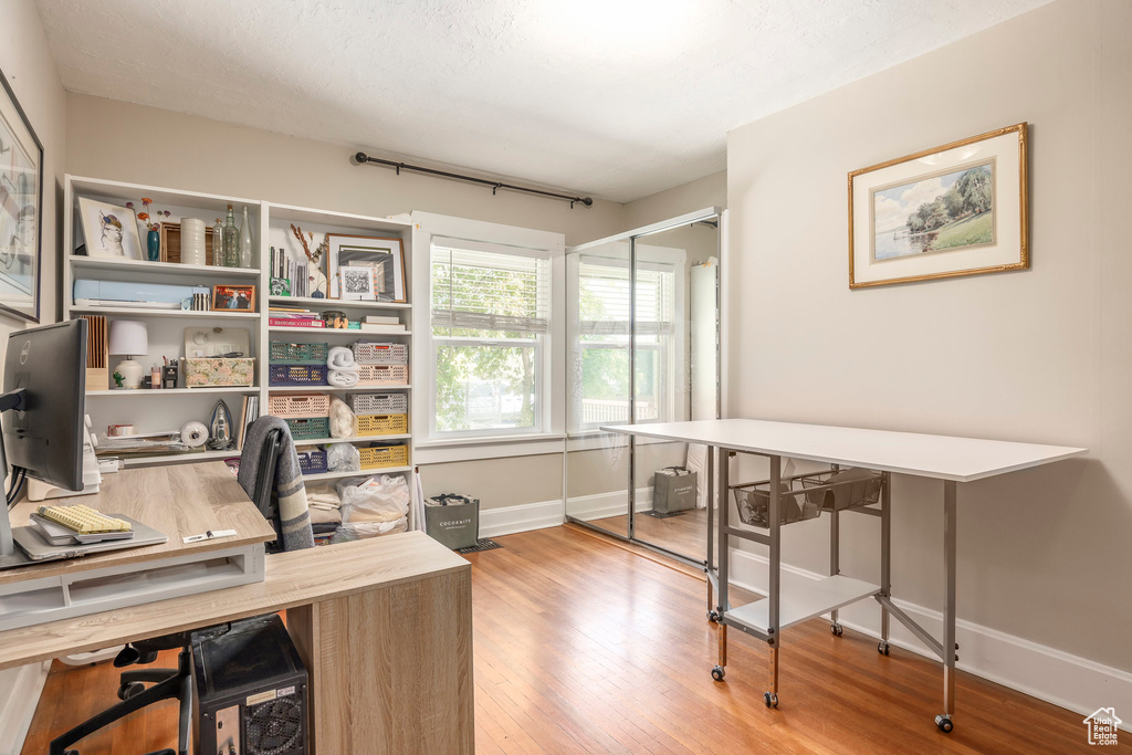 Home office with baseboards and wood finished floors
