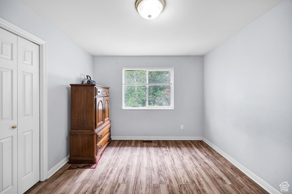 Unfurnished bedroom featuring wood finished floors and baseboards