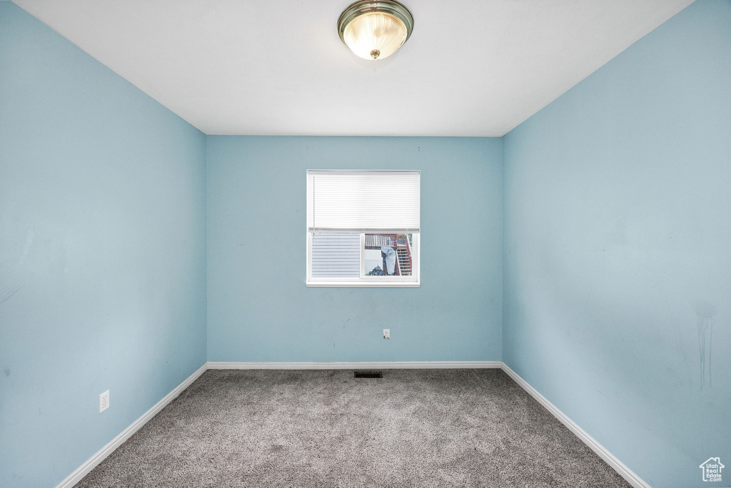 Empty room with carpet flooring and baseboards