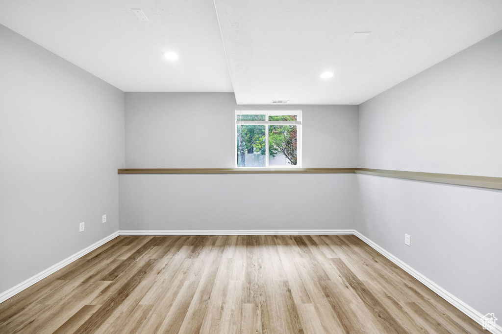 Spare room featuring wood finished floors, baseboards, and recessed lighting