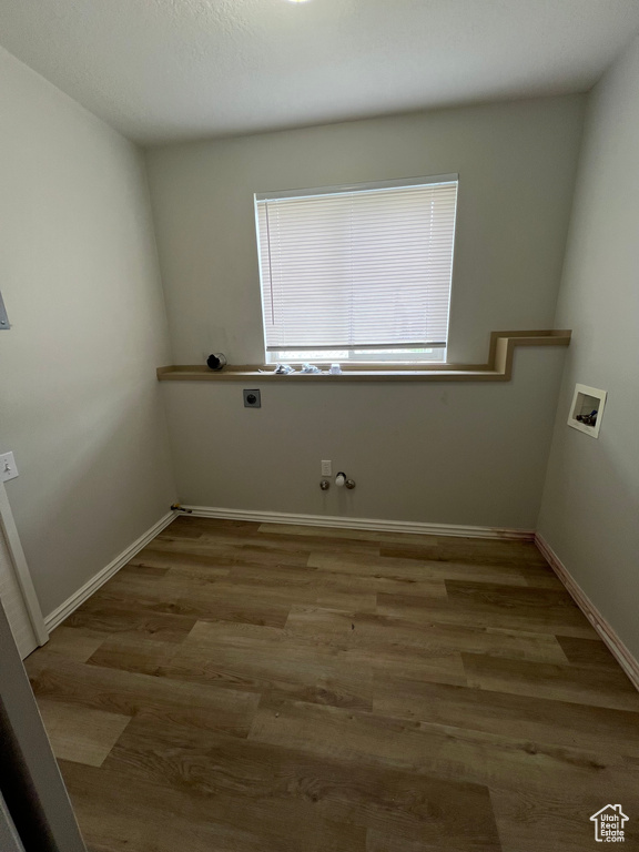 Washroom featuring gas dryer hookup, hookup for a washing machine, wood finished floors, laundry area, and electric dryer hookup