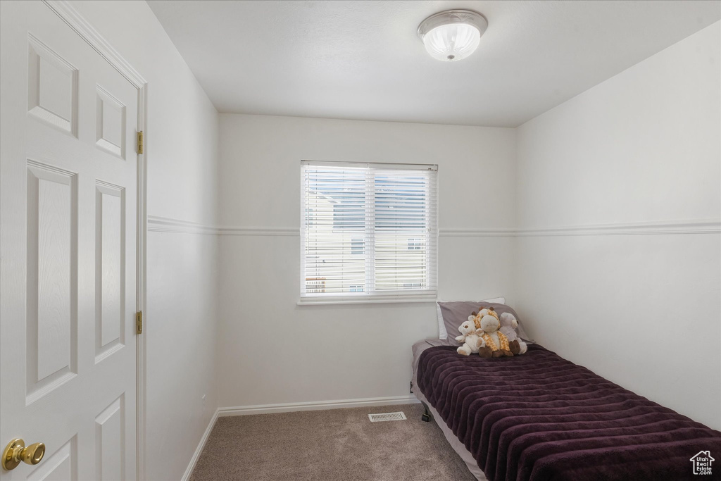 Carpeted bedroom with visible vents and baseboards