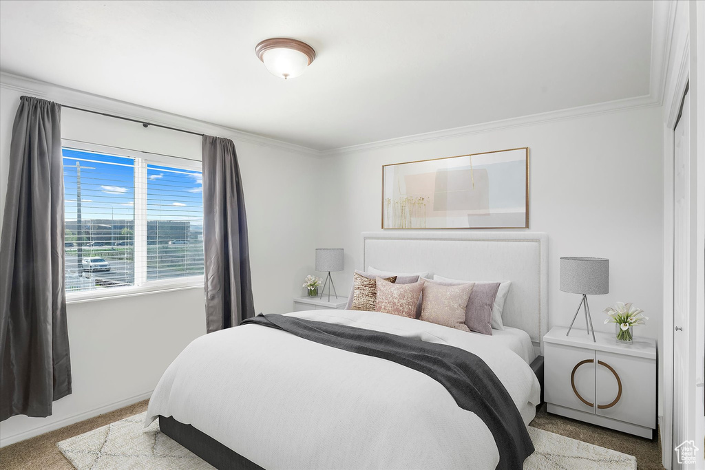Carpeted bedroom with baseboards and ornamental molding