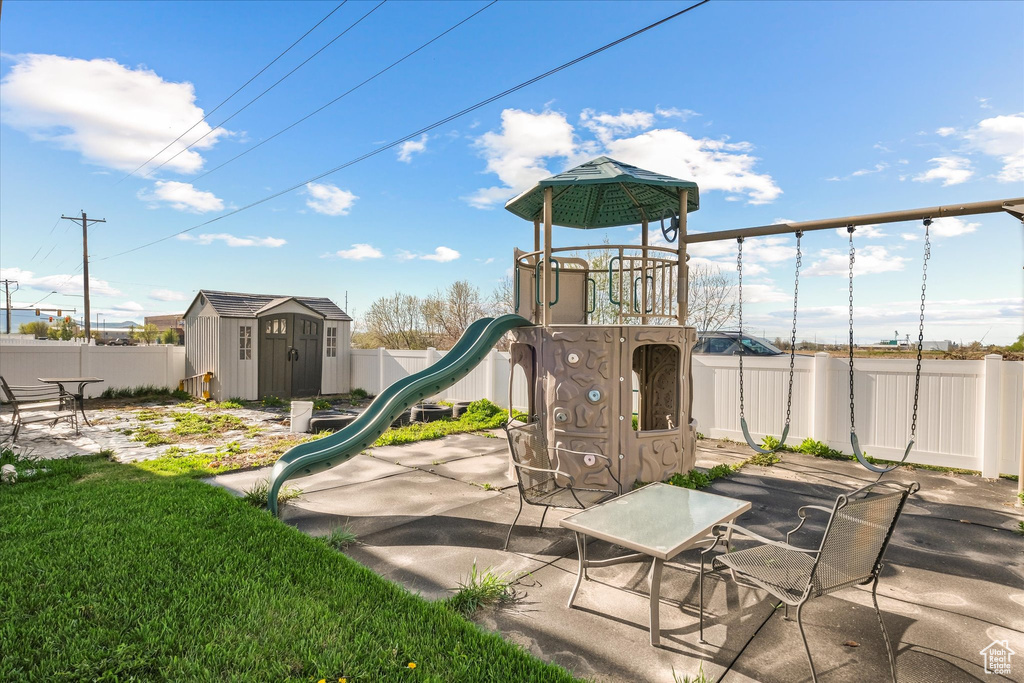View of play area featuring a storage shed, an outbuilding, and a fenced backyard