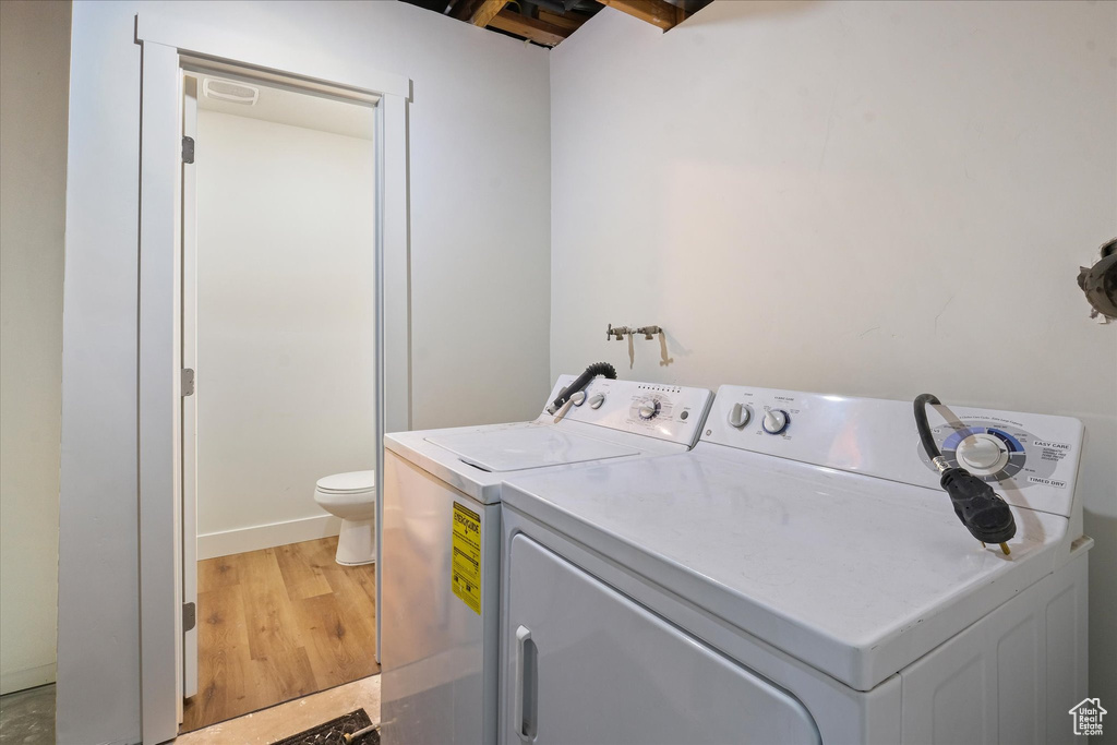 Laundry room with laundry area, light wood-style flooring, and independent washer and dryer