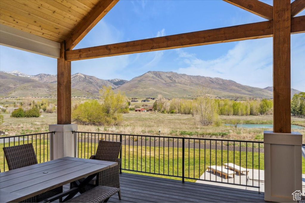 Deck featuring a water and mountain view and outdoor dining space