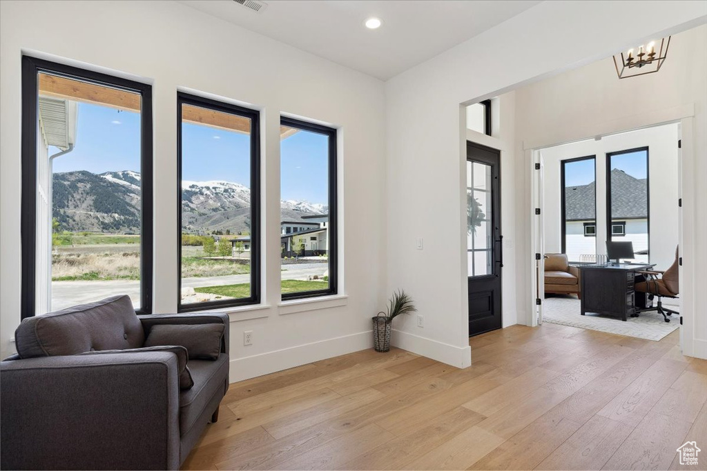 Living area featuring a notable chandelier, light wood-style floors, baseboards, and recessed lighting
