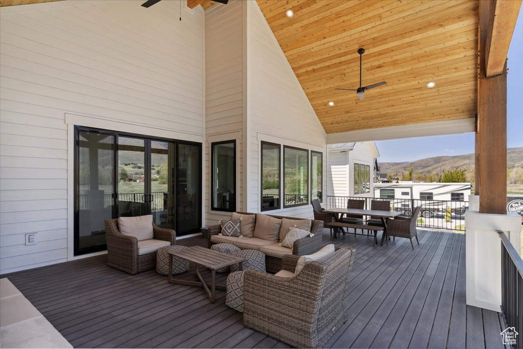 Deck with a mountain view, a ceiling fan, and outdoor dining space