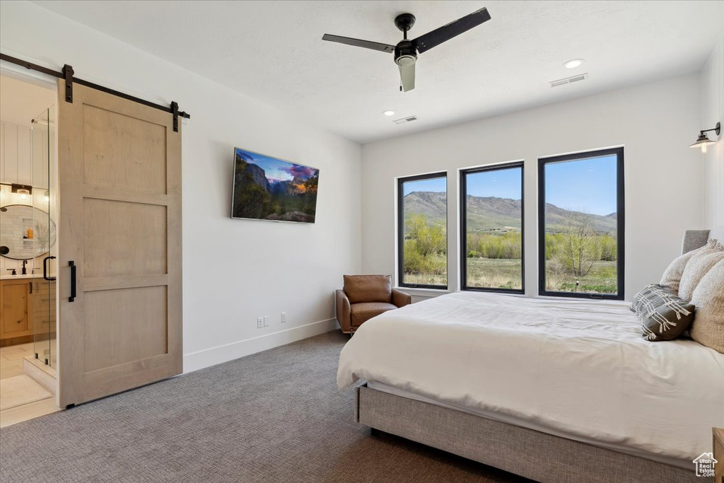 Bedroom with baseboards, carpet flooring, visible vents, and a barn door