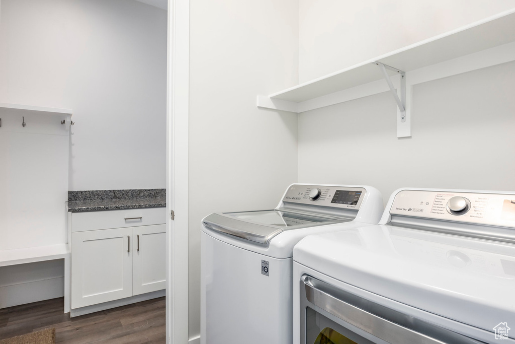 Washroom featuring washer and dryer and dark wood finished floors