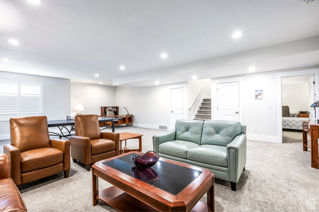Living room with light colored carpet, visible vents, baseboards, and recessed lighting