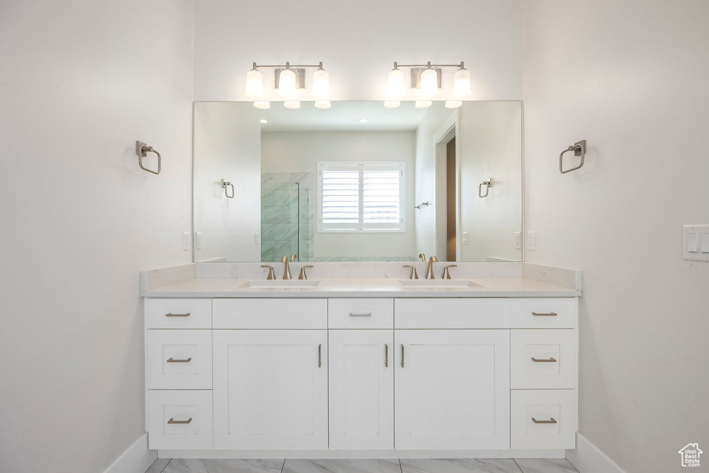 Full bath featuring a sink, a stall shower, and marble finish floor