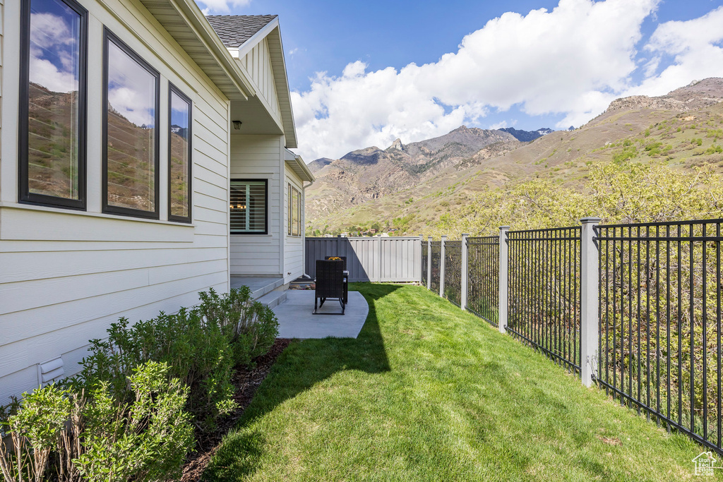 View of yard featuring a patio, a mountain view, and a fenced backyard