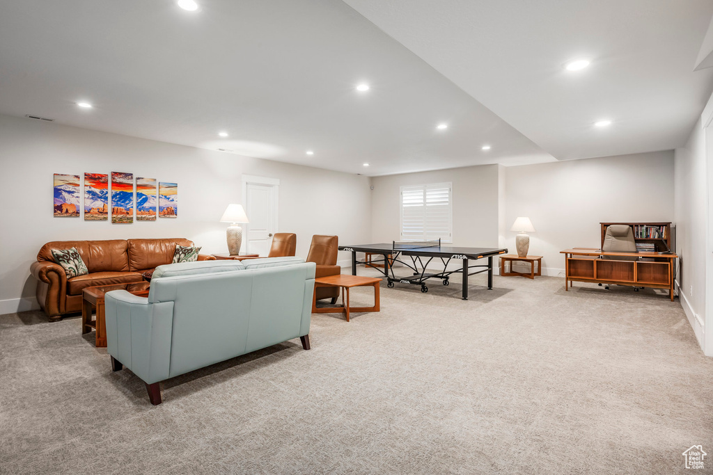 Carpeted living area with baseboards, visible vents, and recessed lighting