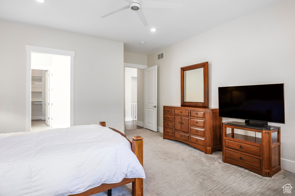 Bedroom featuring light colored carpet, visible vents, recessed lighting, a ceiling fan, and a walk in closet