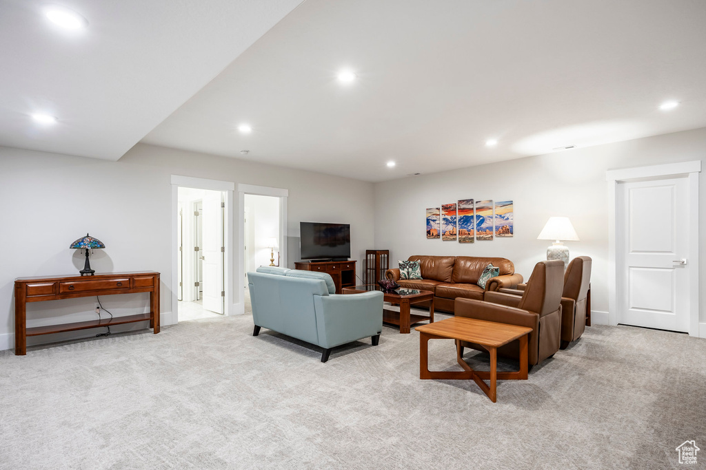 Living area featuring light colored carpet, baseboards, and recessed lighting