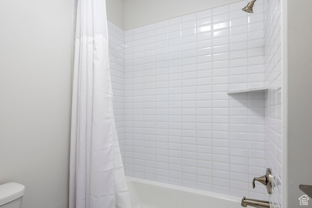 Full bath featuring toilet and shower / tub combo with curtain