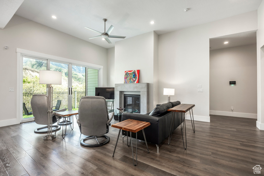 Living area with a ceiling fan, baseboards, a high end fireplace, and wood finished floors