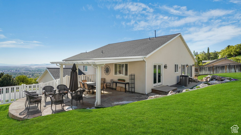 Back of property with a yard, a patio area, stucco siding, and a fenced backyard
