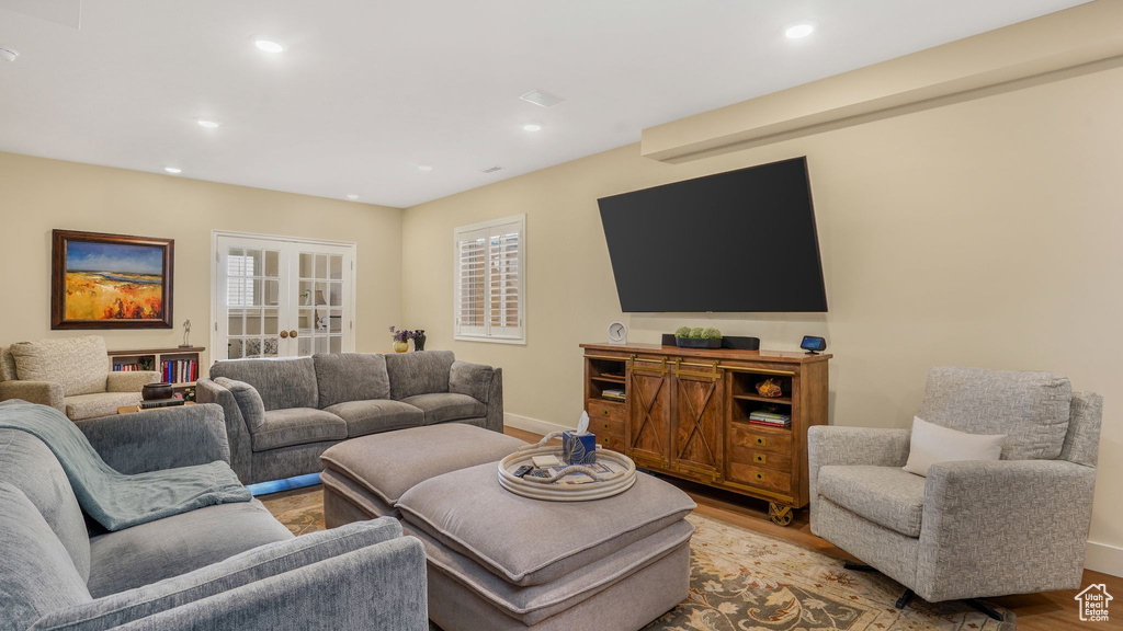 Living room with baseboards, light wood finished floors, french doors, and recessed lighting