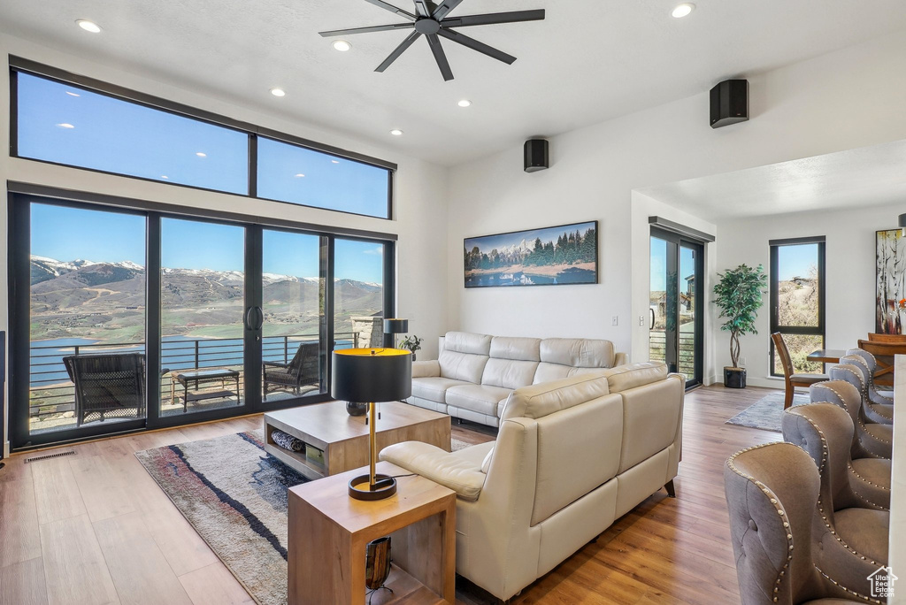 Living area with recessed lighting, a healthy amount of sunlight, ceiling fan, and wood finished floors