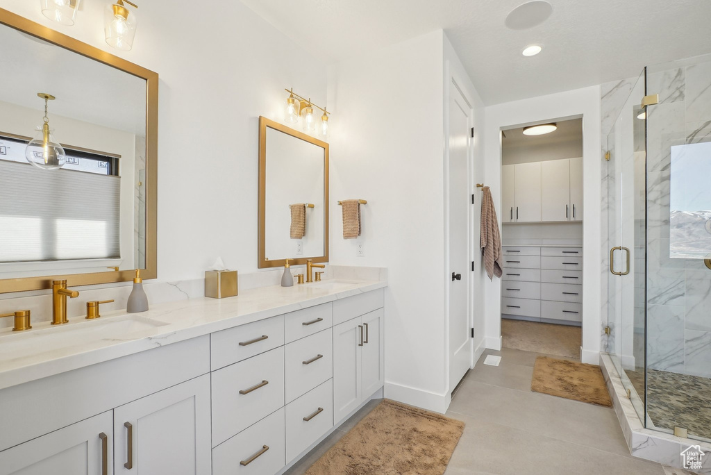 Bathroom with double vanity, a marble finish shower, and a sink