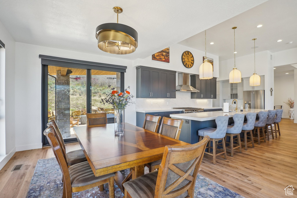 Dining area featuring baseboards, light wood-type flooring, visible vents, and recessed lighting