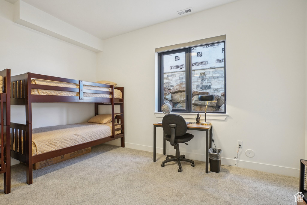 Carpeted bedroom featuring baseboards and visible vents