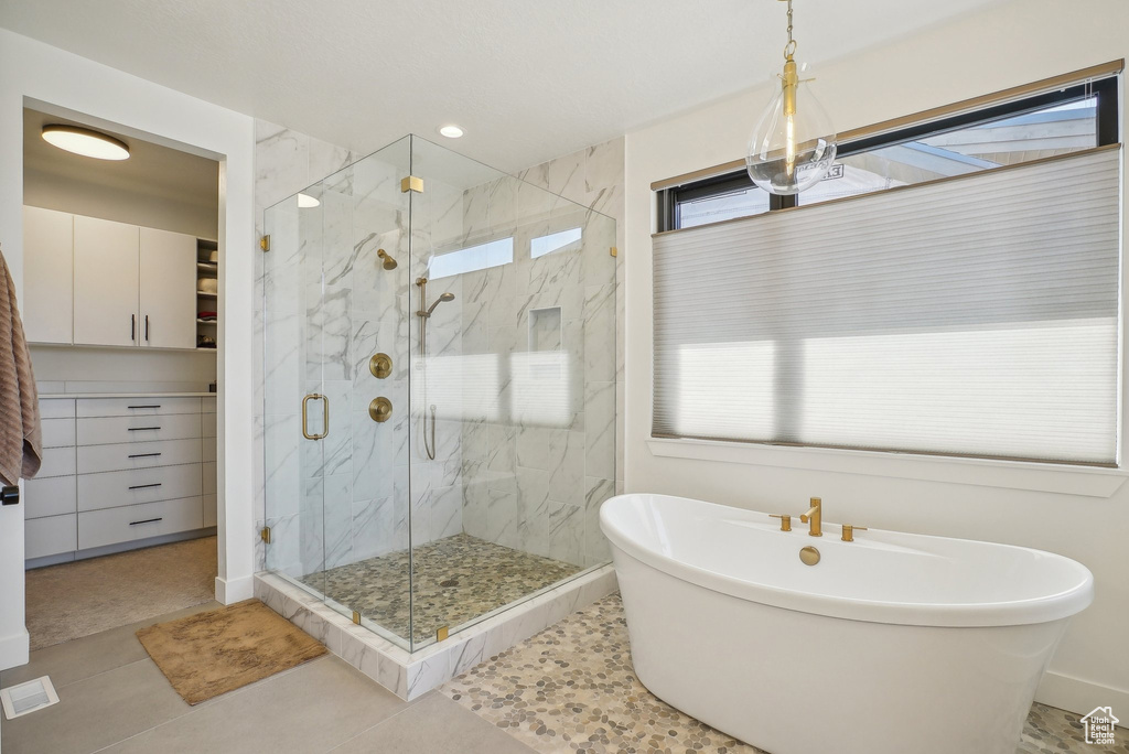 Full bath with tile patterned floors, a marble finish shower, a freestanding tub, and recessed lighting