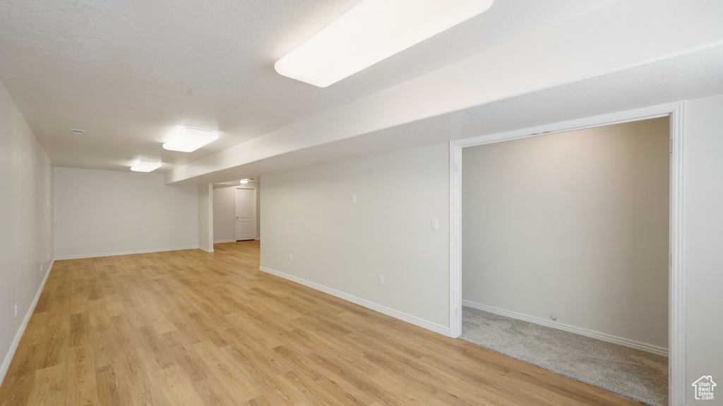 Finished basement with baseboards and light wood finished floors