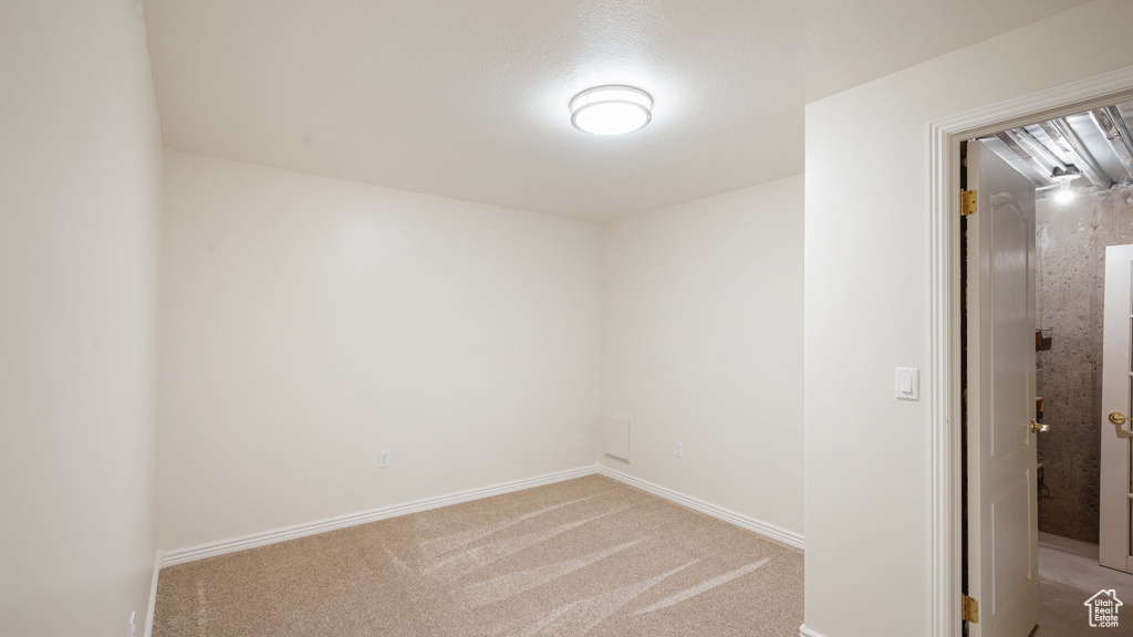 Empty room featuring light colored carpet and baseboards