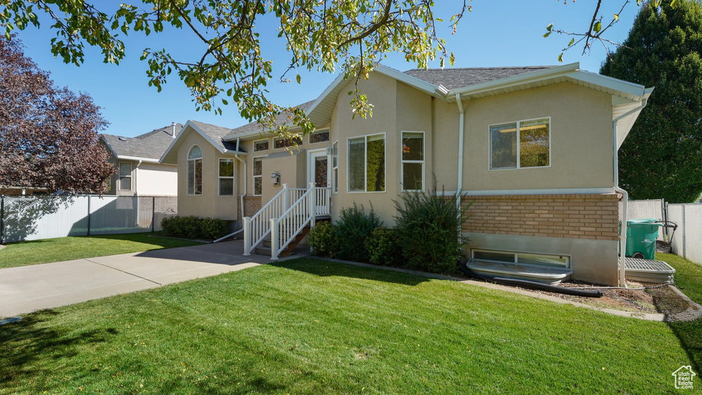 Ranch-style home with fence, stucco siding, brick siding, and a front yard