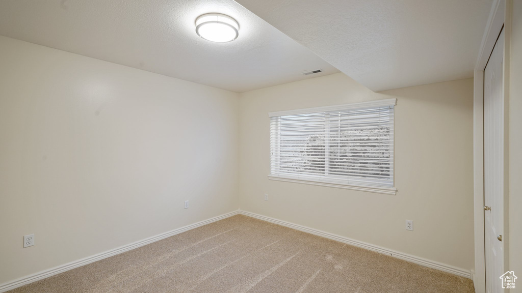 Unfurnished room with baseboards, carpet flooring, and visible vents