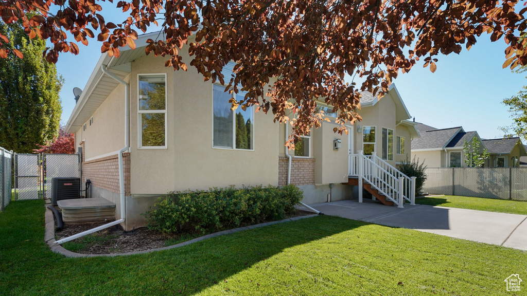 Bungalow featuring fence, a front lawn, and stucco siding