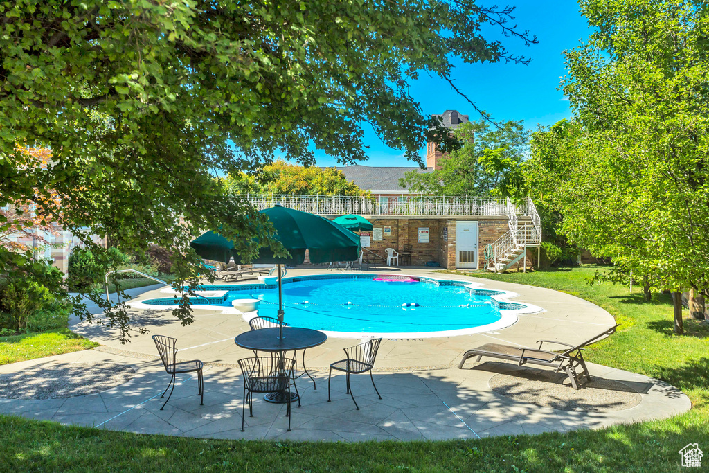 Outdoor pool with a yard, a patio area, and stairway