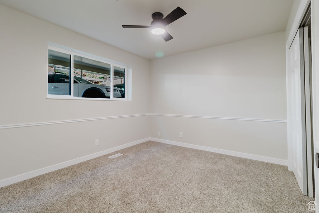 Spare room featuring ceiling fan, carpet floors, baseboards, and visible vents