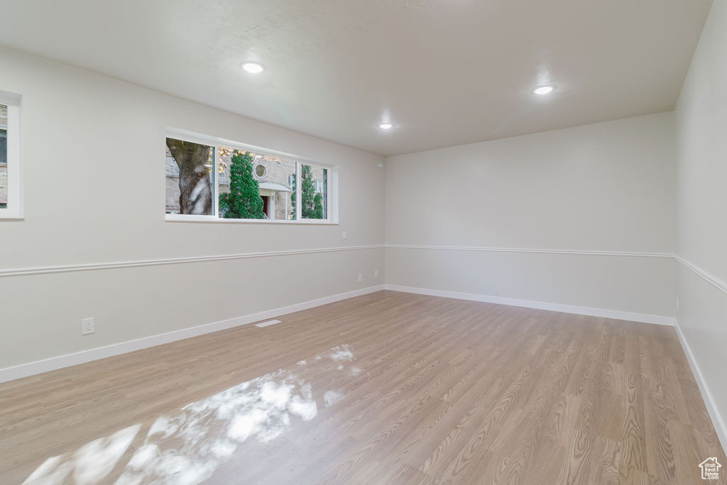 Empty room featuring wood finished floors, baseboards, and recessed lighting