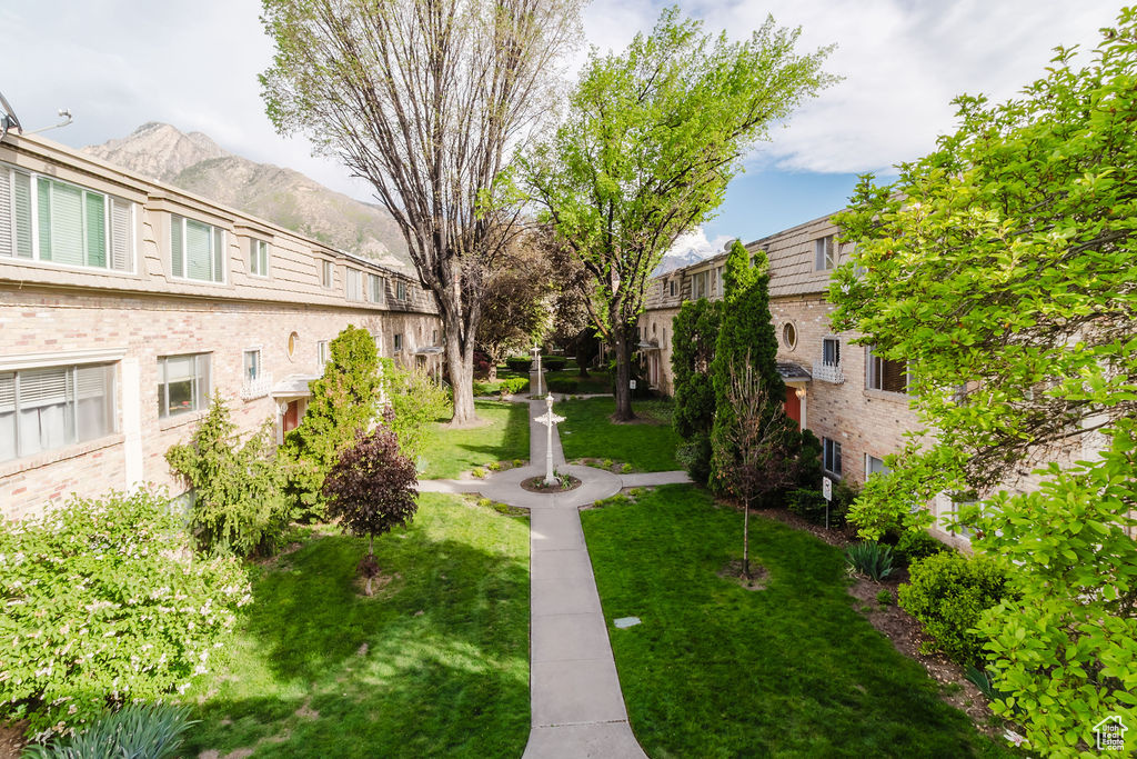 View of property's community featuring a mountain view and a lawn