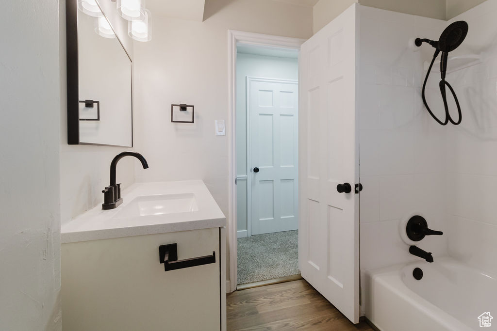 Bathroom featuring bathtub / shower combination, wood finished floors, and vanity