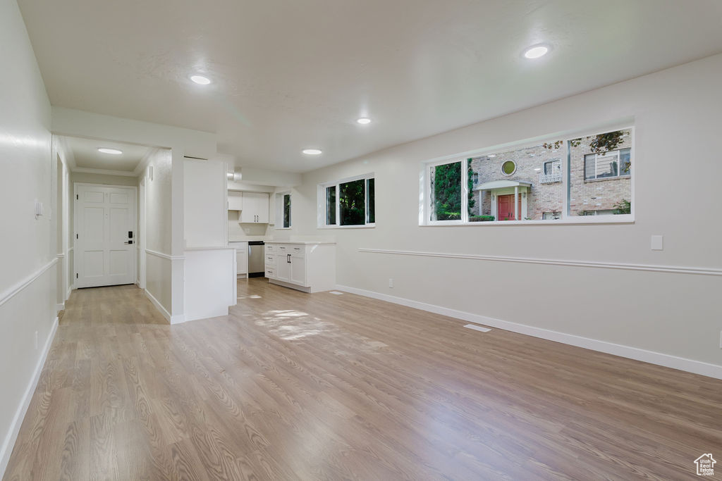 Unfurnished living room featuring baseboards, light wood finished floors, recessed lighting, and visible vents