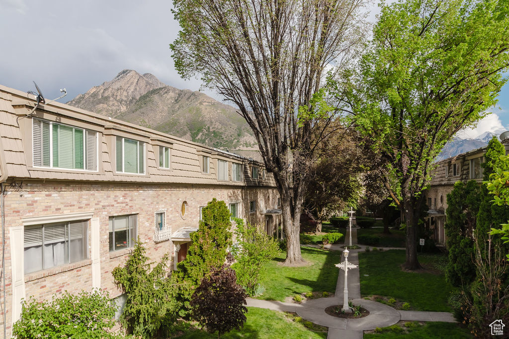 View of home's exterior with brick siding, a mountain view, and a lawn
