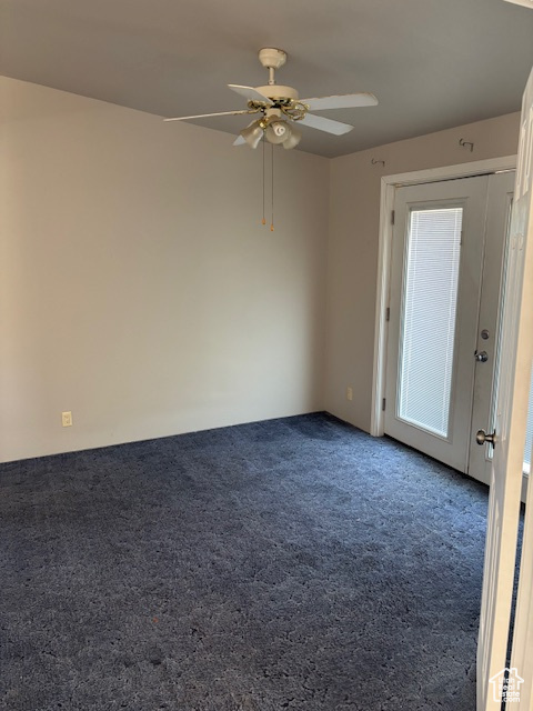 Carpeted spare room featuring a ceiling fan