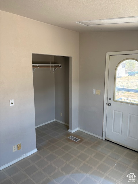 Entrance foyer with visible vents, baseboards, a textured ceiling, and tile patterned floors