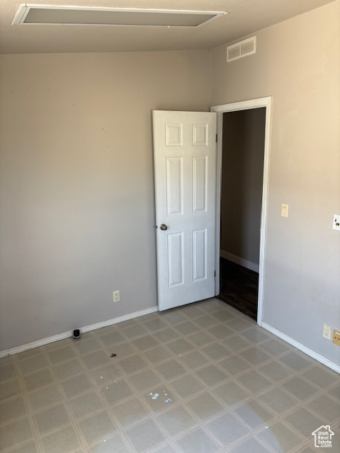 Spare room with tile patterned floors, visible vents, and baseboards