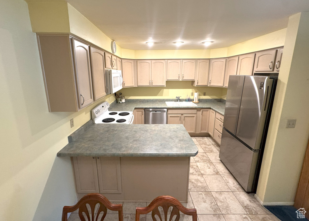 Kitchen with a sink, appliances with stainless steel finishes, and a peninsula