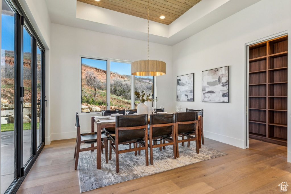 Dining room featuring wooden ceiling, a raised ceiling, a wealth of natural light, and baseboards