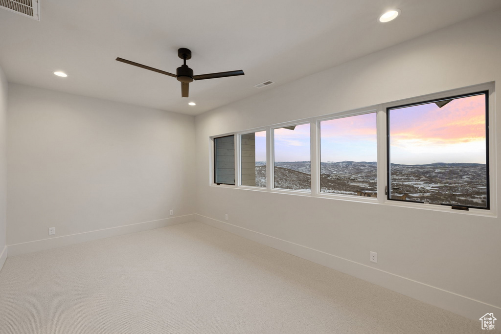 Carpeted empty room with ceiling fan, baseboards, visible vents, and recessed lighting