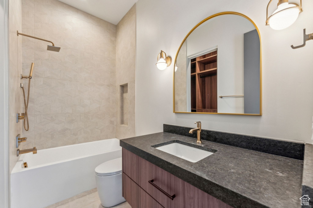 Full bathroom featuring toilet, washtub / shower combination, and vanity
