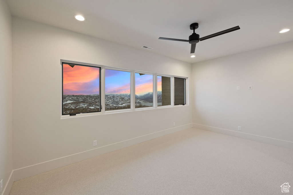 Spare room featuring carpet, a ceiling fan, visible vents, baseboards, and recessed lighting